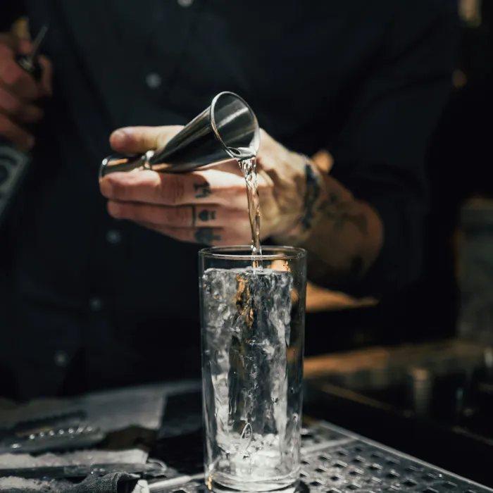 Barkeeper Praktikant mischt einen leckeren Longdrink