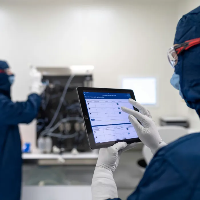 Personen, die im Labor mit elektronischer Batch Record-Software arbeiten.