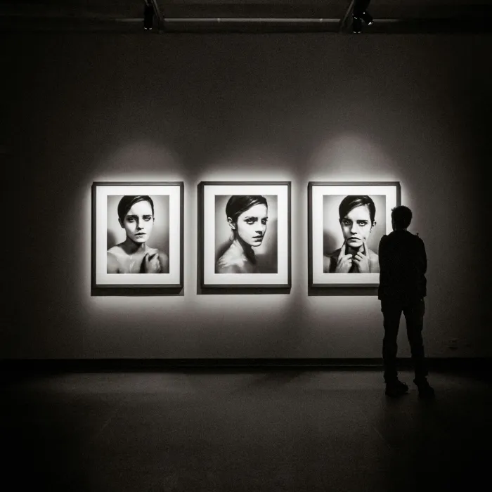 Kuratorin (während des Praktika) steht vor 3 großen Bildern einer Ausstellung